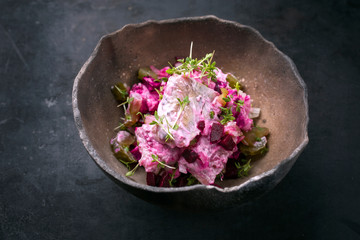 Traditioneller Matjes Hering Filet mit Rote Beete Salat und Zwiebel angeboten als closeup in einer...