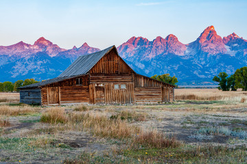 Historic mormon barn in front of the Grand Tetons at sunrise, Grand Teton National Park, Wyoming.
