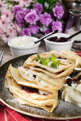 Crepes with ricotta cheese and blackcurrant jam.