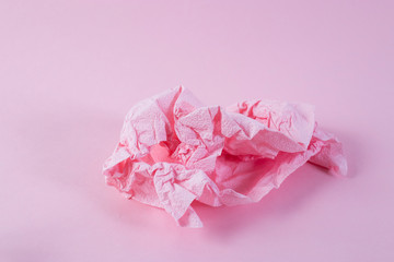 Crumpled pink napkin on pink background