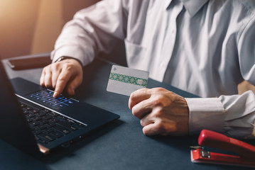 Online payment, woman's hands holding a credit card and using laptop for online shopping. Business,financial  concept