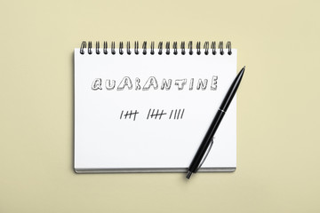 Open notebook and pen on light background, top view. Counting days of quarantine during coronavirus outbreak