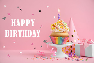 Text Happy Birthday, party items and delicious cupcake with candle on pink background
