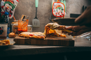 selective focus of italian pizza, spices in grinders, bottle and glass of wine on wooden tabletop