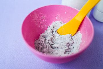 Dry gray bentonite clay powder in a bowl. Diy facial mask and body wrap recipe. Natural beauty treatment and spa. Clay texture closeup, selective focus.