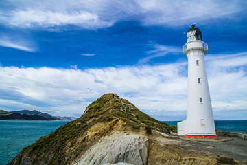 Fototapeta na wymiar Travel New Zealand, North Island. Beautiful scenic landscape, panoramic view of Castlepoint Lighthouse. Tourist popular attraction/landmark in Wairarapa area.