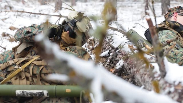 Soldier talks on the radio, takes Man-portable air-defense systems and aims