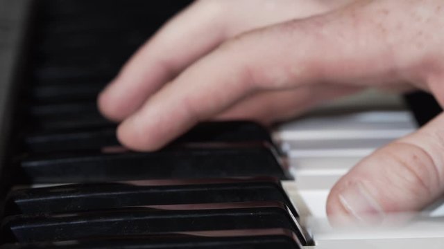 Right hand of man playing keyboard. Close up on fingers. Entertainment during quarantine.