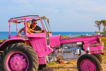 Beautiful couple together on a pink tractor, just married