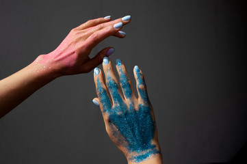 hands in glitter on a black background with space for text - Powered by Adobe