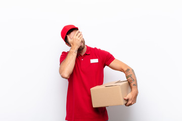 looking stressed, ashamed or upset, with a headache, covering face with hand. delivery concept