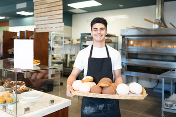 Baker showing a tray of sweet bread