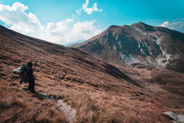 Obraz premium Hiking trough epic mountain landscape with a big backpack, exploring and feeling the freedom of nature