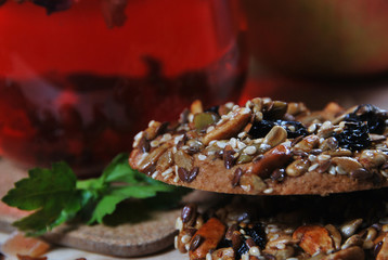 two shortbread cookies with different seeds with caramel and fruit tea