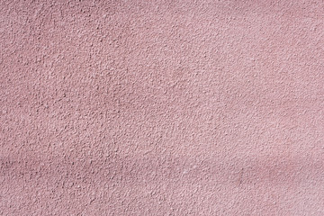 Fototapeta premium Textured wall of the building. Light pink wall.