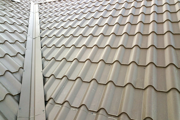 Close up of new house roof structure covered with metal tile sheets.
