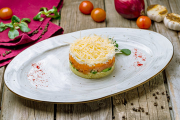 Mimosa salad on a plate on wooden table