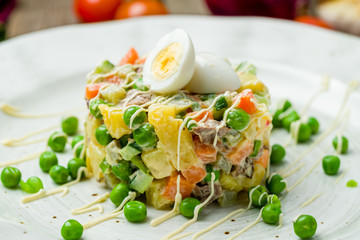 salad olivier on plate on wooden table