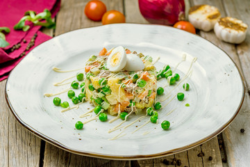 salad olivier on plate on wooden table