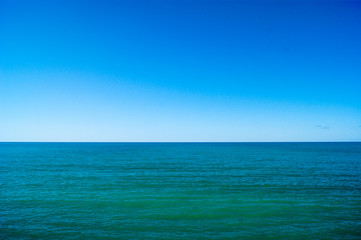 Fototapeta na wymiar Calm sea and blue sky, horizontal photo.