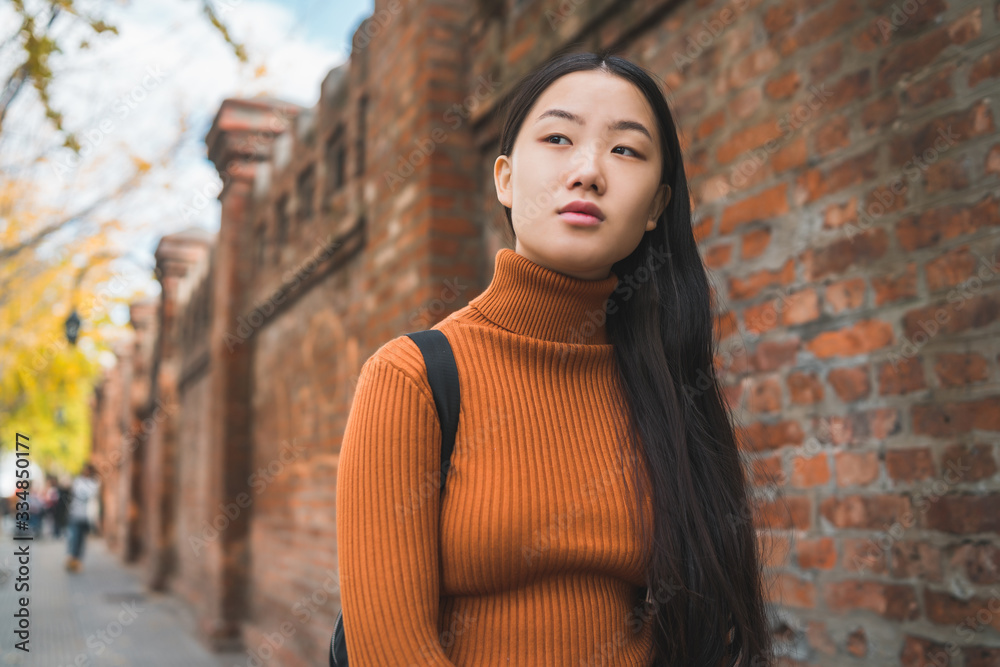 Wall mural portrait of young asian woman in the street.