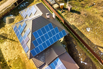 Aerial top view of new modern residential house cottage with blue shiny solar photo voltaic panels...
