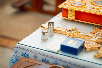 Accessories for infant baptism. Closeup.The sacrament of baptism. baptismal font and jug. The sacrament of baptism. Attributes of an Orthodox priest for baptism. Cross on table.