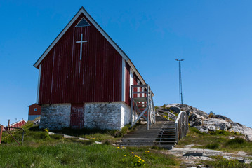 Red church of the fishing town in Greenland. Blue sky in the background.