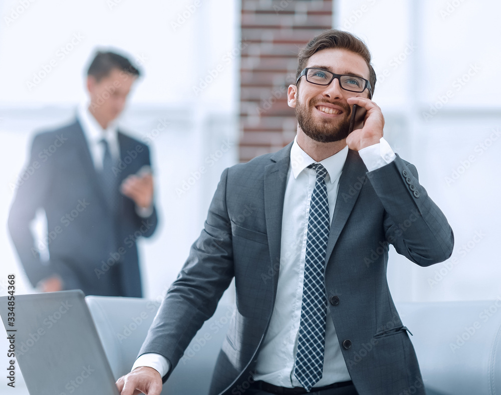 Wall mural Confident young man talking on phone in office