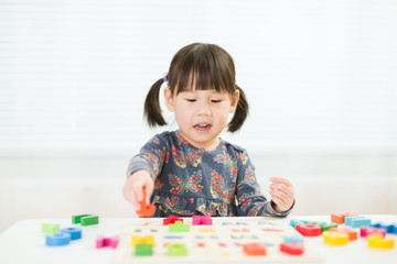 toddler girl learning letter blocks for homeschooling