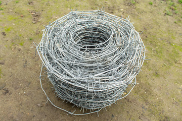 A roll of barbed wire over natural background