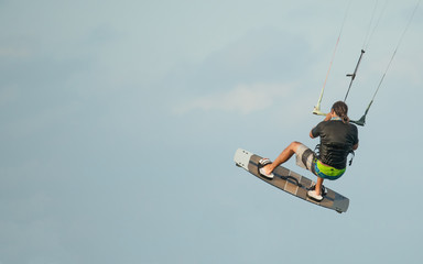 Kiteboarder or kite surfer. Man performing kitesurfing kiteboarding tricks.
