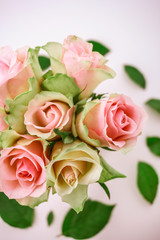 Close up bouquet of pink spring roses in glass vase on white.