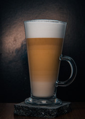 cup of latte with cream on black background