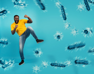 Fototapeta na wymiar African-American man fighting with bare hands against viruses and bacteria on cyan background