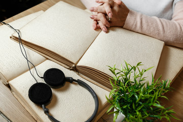 woman reading braille text on old book