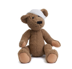 brown teddy bear with a bandaged head in a white medical bandage on a white background