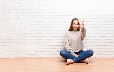 young blonde pretty girl smiling and looking friendly, showing number four or fourth with hand...