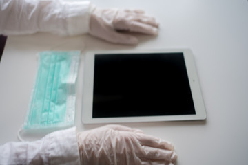 Close up on hands in medical gloves using tablet computer. Protective care. Emergency problem. Healthcare employee practitioner, distance working and learning concept. Modern technology background.