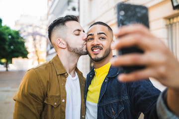 Gay couple taking a selfie in the street.