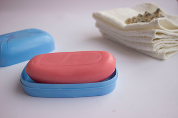 Hand soap is pink and there are towels in the background