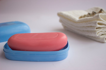 Hand soap is pink and there are towels in the background