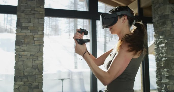 An young rich woman is using innovative technology vr glasses for playing boxing workout in a luxury apartment. Shot in 8K. Concept of future, innovation, technology, gaming,lifestyle, virtual sports