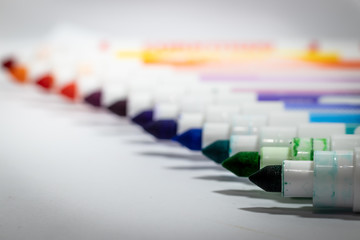 Markers in all rainbow colors, white background
