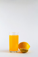 glass of fresh orange juice with ripe lemon on white table. vitamin C to strengthen the immune system. Healthy lifestyle. citrus fruit on white background. copy space