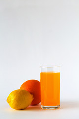 glass of fresh orange juice with ripe orange and lemon on white table. vitamin C to strengthen the immune system. Healthy lifestyle. citrus fruit on white background. copy space