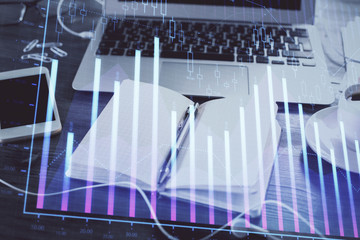Multi exposure of financial graph drawings and desk with open notebook background. Concept of forex
