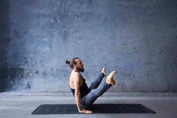 Man practicing yoga, core practice, arm balance. 