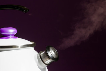 Steam comes from the spout of the kettle.