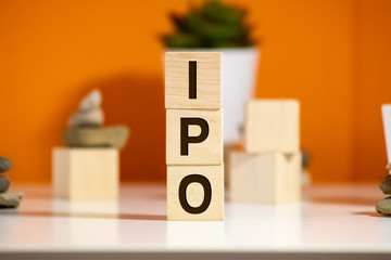 IPO Initial Public Offering written on a wooden cube in front of a laptop